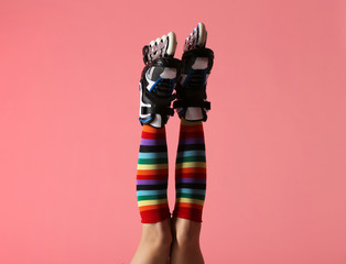 Woman with roller skates on color background, closeup