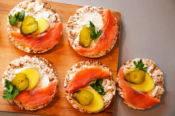 Sandwiches with cottage cheese, red fish, ginger and pickled cucumber on a cereal loaf