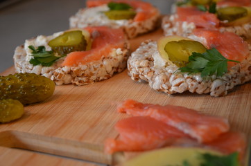 Sandwiches with cottage cheese, red fish, ginger and pickled cucumber on a cereal loaf