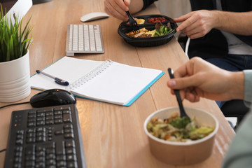 Office employees having lunch at workplace, closeup. Food delivery