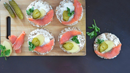 Sandwiches with cottage cheese, red fish, ginger and pickled cucumber on a cereal loaf