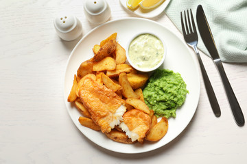 British Traditional Fish and potato chips on wooden background, flat lay