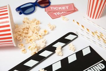 Clapper, popcorn and tickets on white background. Cinema snack
