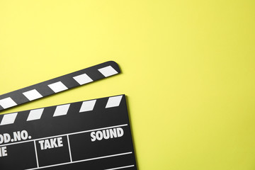 Fototapeta na wymiar Clapperboard on color background, top view with space for text. Cinema production