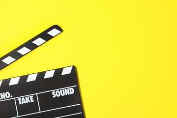 Fototapeta na wymiar Clapperboard on color background, top view with space for text. Cinema production