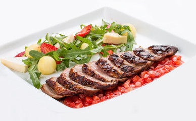 Duck breast with arugula and strawberry chutney on white background