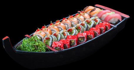 Sushi set in a wooden boat on a black background