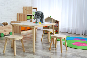 Modern child room interior with table and stools