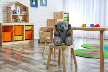 Stuffed rabbit on stool in child room interior