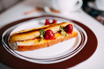 Roasted banana dessert with raspberries on the plate