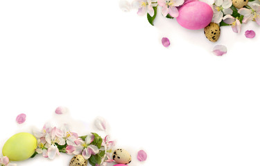 Easter decoration. Frame of pink flowers apple tree, colored easter eggs and quail eggs on white background with space for text. Top view, flat lay