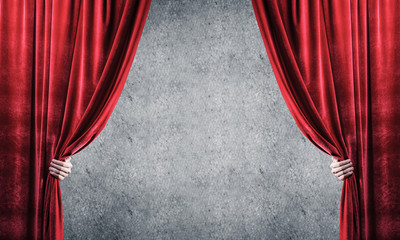 Concrete wall behind drapery curtain and hand opening it