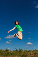 Girl jumping, running against blue sky