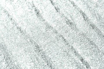 teal, sea-green shiny sand made of aluminium glitters with selective focus and small bokeh texture - beautiful abstract photo background