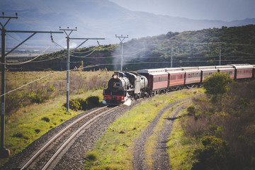 Close up image of an old steam engine on a railway track in south africa