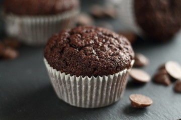Chocolate homemade cupcakes muffins on a black background with chocolate drops in the background. Bakery style. Dark food photo