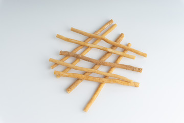 Natural toothbrush Miswak (Kayu Sugi) on white background with selective focus. It is a teeth cleaning twig made from the Salvadora persica tree and also know as miswaak, siwak, Sugi or sewak