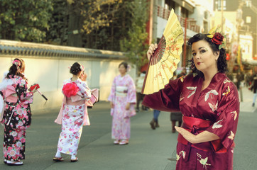 A caucasian woman dressed as a Japanese woman poses in Asakusa district