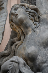 Fototapeta na wymiar Facade statue of sensual Rococo Era woman at New Palace in Potsdam, Germany, details, closeup