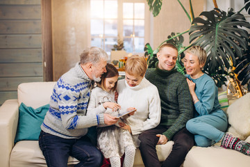 grandfather is telling stories to his son, daughters and graddaughter about his youth. old man...