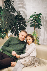 Fototapeta premium close up portrait of handsome father and his cute daughter sitting on the sofa. love, relation, fatherhood, parenthood.