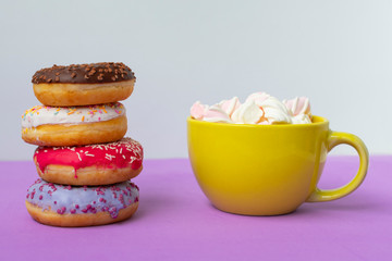donuts lying on top of each other and cup of marshmallow