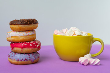 donuts lying on top of each other and cup of marshmallow