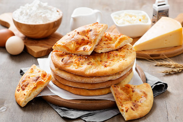 Freshly baked khachapuri with cheese on a wooden table.