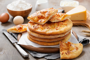 Freshly baked khachapuri with cheese on a wooden table.