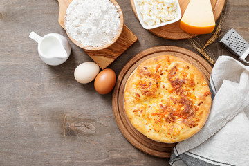 Freshly baked khachapuri with cheese on a wooden table.