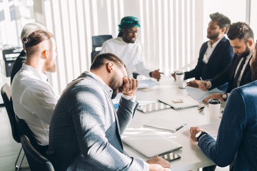 Multiracial group of experts headed by Arab leader, dressed in national white wear, analyzing business result and discussing profit.