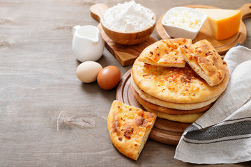 Freshly baked khachapuri with cheese on a wooden table.