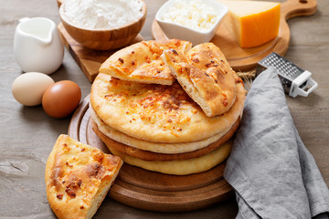 Freshly baked khachapuri with cheese on a wooden table.
