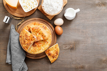 Freshly baked khachapuri with cheese on a wooden table.