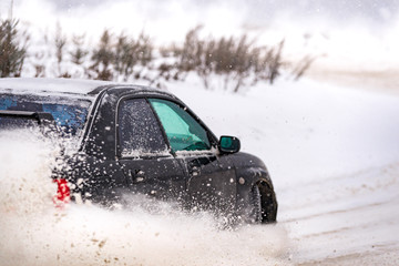 Closeup of car back in winter on the road covered with snow