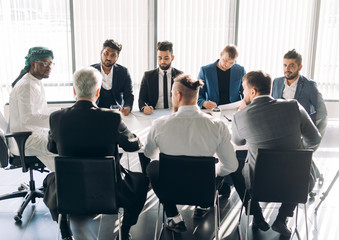 Focus group of advertising agency male stuff dressed in business suits sitting, headed by Executive...