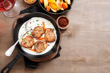 Pork meat medallions with baked potatoes and cream sauce .