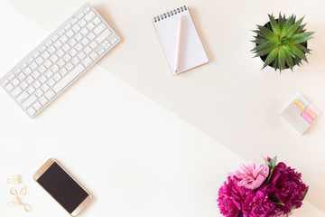 Top view of office table desk or fashion woman workspace with computer keyboard, blue diary, green potted cactus flower background. Flat lay