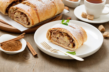 Homemade apple strudel with fresh apples, nuts and powdered sugar.