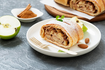 Homemade apple strudel with fresh apples, nuts and powdered sugar.