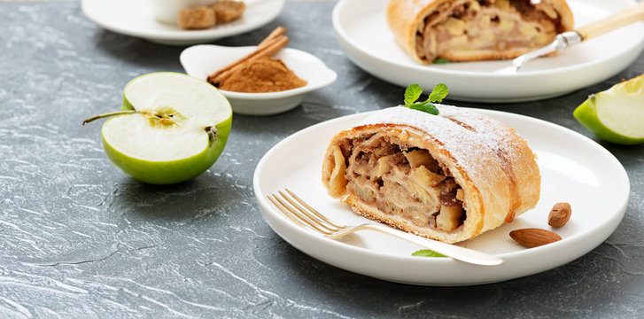 Homemade apple strudel with fresh apples, nuts and powdered sugar.