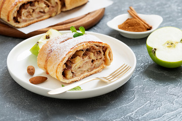 Homemade apple strudel with fresh apples, nuts and powdered sugar.