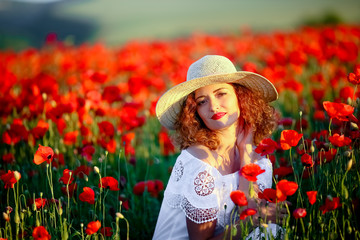 Beauty blue eyes teen enjoy summer days .Cute fancy dressed girl in poppy field. Field of blooming poppies.