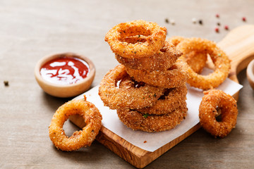 Delicious golden battered, breaded and deep fried crispy onion rings with ketchup.