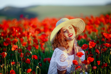 Beauty blue eyes teen enjoy summer days .Cute fancy dressed girl in poppy field. Field of blooming poppies.