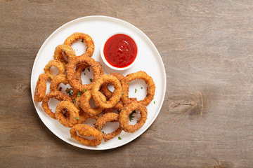 Delicious golden battered, breaded and deep fried crispy onion rings with ketchup.