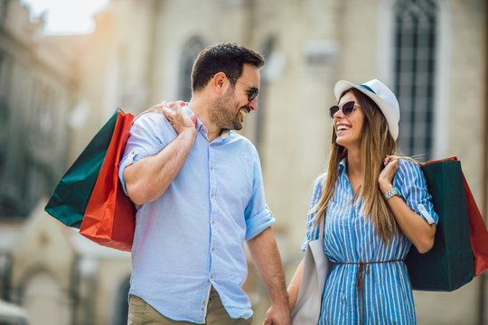 Beautiful young couple enjoying in shopping, having fun in the city