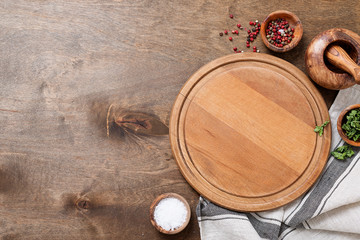Spices, Herbs, Cutting board for cooking. Round wooden cutting board on wooden  backdrop.