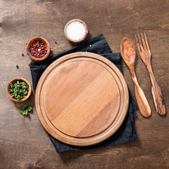 Spices, Herbs, Cutting board for cooking. Round wooden cutting board on wooden  backdrop.