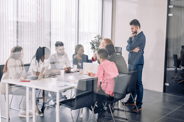Fototapeta premium Caucasian young male head of department waits his subordinates to complete a task, that he gave two hours earlier in meeting room. Toned image